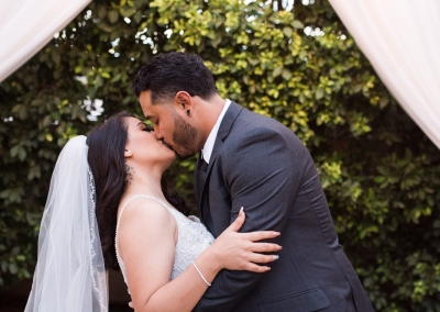 Garden Tuscana Reception Hall event in Mesa showing couple kiss under outdoor gazebo