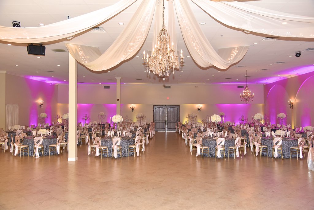 Large quinceañera reception set up with round tables and gold chairs in the Garden Tuscana ballroom