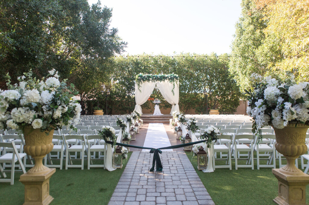 Reception tables set with linens, centerpieces and place settings in the Garden Tuscana ballroom